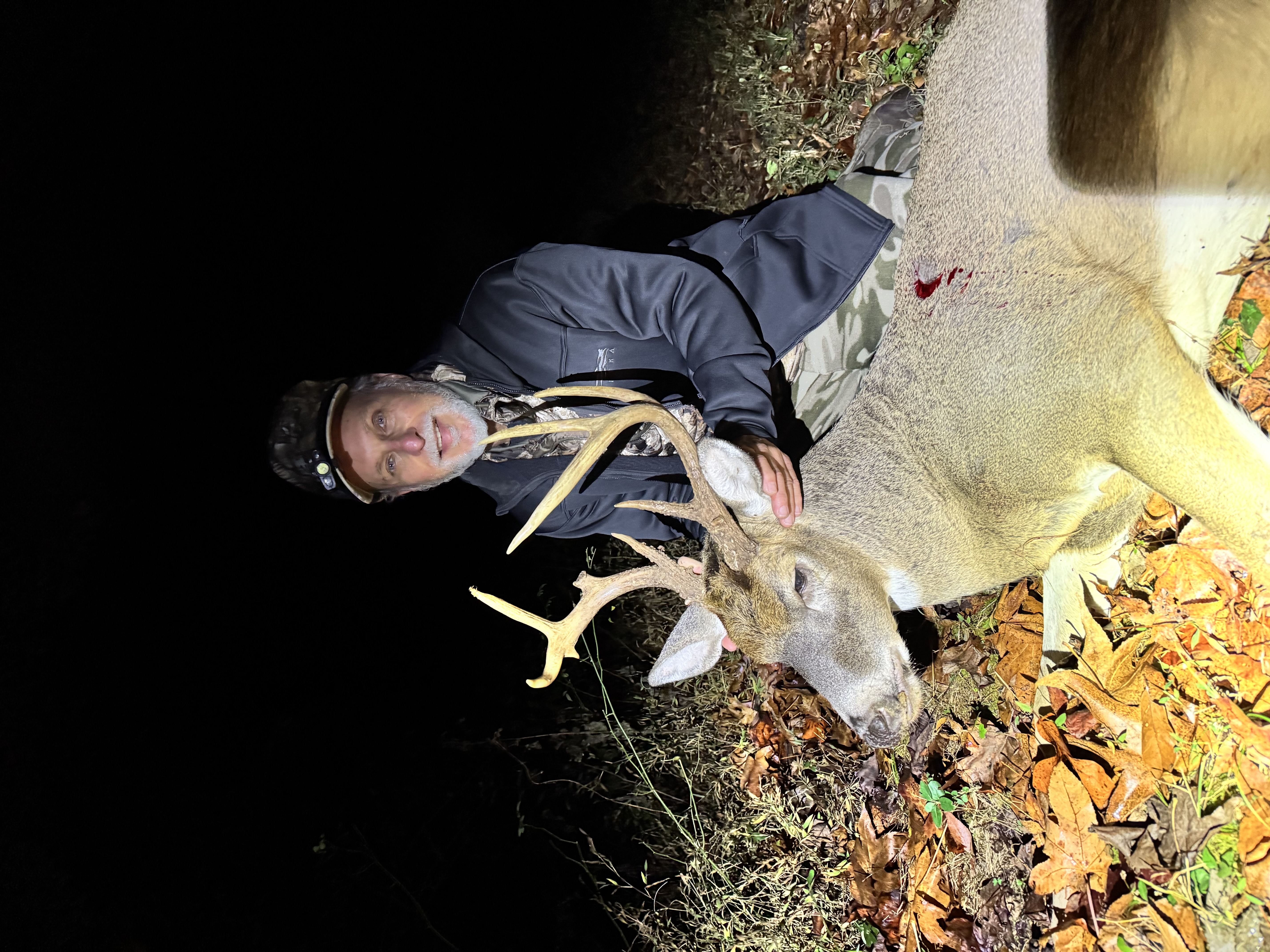 Hunter with harvested whitetail buck at night in Western Kentucky