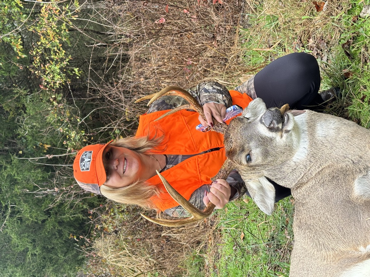 Hunter with whitetail buck in the field