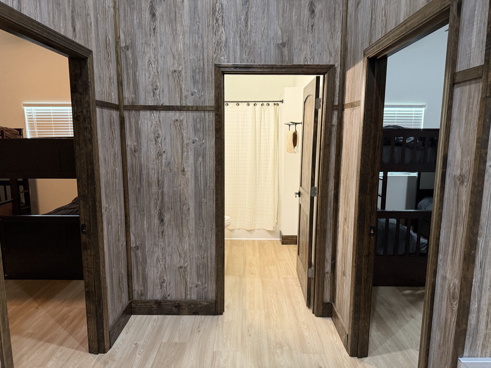 Private guest wing with two bunk-style bedrooms flanking a full bathroom